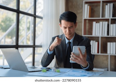 Stressed businessman calculating bills and taxes looking at calculator gesturing with hands sitting at work desk. - Shutterstock ID 2278090155