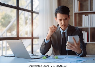 Stressed businessman calculating bills and taxes looking at calculator gesturing with hands sitting at work desk. - Shutterstock ID 2278090163