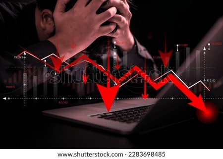Stressed businessman and financial failure graphs showing loss