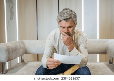 stressed businessman opening envelope reading bad news in mail letter. Mad man feels frustrated about high bills, dismissal notice, bank debt, tax invoice or mistake