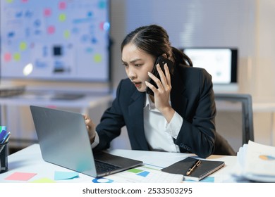 Stressed businesswoman in her office, arguing on the phone and working on her laptop, reflects the challenges of a demanding corporate environment - Powered by Shutterstock