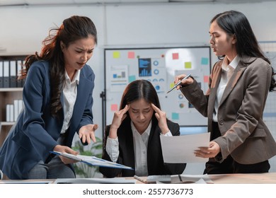 Stressed businesswoman overwhelmed by colleagues' blame, highlighting work-life challenges in corporate setting - Powered by Shutterstock