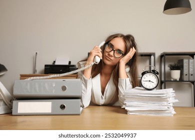 Stressed businesswoman talking by telephone and trying to meet deadline in office - Powered by Shutterstock