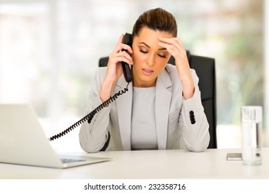 stressed businesswoman talking on telephone in office - Powered by Shutterstock