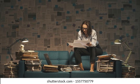 Stressed businesswoman working on the sofa late at night, she is overloaded with work, deadlines and overtime work concept - Shutterstock ID 1557750779