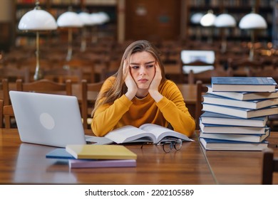 Stressed college student tired of hard learning with books and laptop in exams tests preparation, overwhelmed high school teen girl exhausted with difficult studies or too much homework. - Shutterstock ID 2202105589