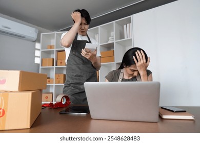 Stressed Couple Analyzing Stock Market Data Online at Home with Laptop and Smartphone - Powered by Shutterstock