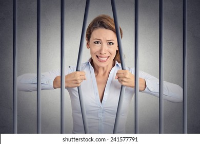 Stressed Desperate Angry Businesswoman Bending Bars Of Her Prison Cell Grey Wall Background. Life Limitations, Law Violation Infringement Tax Evasion Consequences Concept. Face Expression Emotion