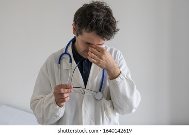 Stressed Doctor With Hand On His Face. Burn Out Concept For Healthcare Professions