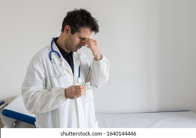 Stressed Doctor With Hand On His Face. Burn Out Concept For Healthcare Professions