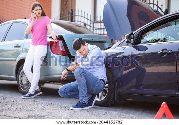 Stressed drivers\
near broken cars after\
accident