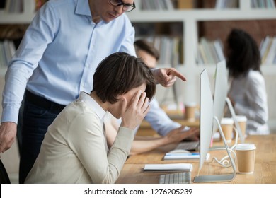Stressed employee intern suffering from gender discrimination or unfair criticism of angry male boss shouting scolding firing female worker for bad work, computer mistake or incompetence in office - Shutterstock ID 1276205239