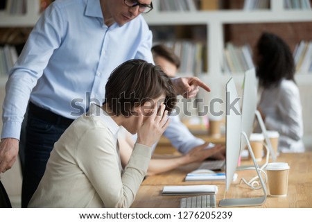 Stressed employee intern suffering from gender discrimination or unfair criticism of angry male boss shouting scolding firing female worker for bad work, computer mistake or incompetence in office Foto stock © 