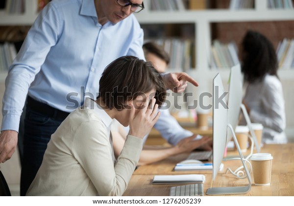 Stressed employee intern suffering from gender\
discrimination or unfair criticism of angry male boss shouting\
scolding firing female worker for bad work, computer mistake or\
incompetence in office