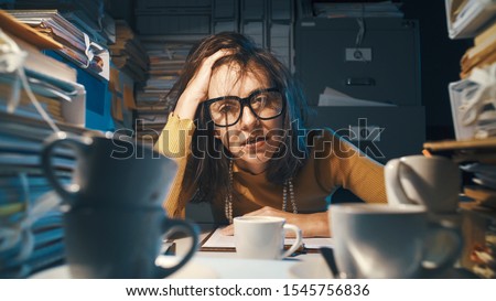 Stressed exhausted woman sitting at office desk and working overtime, she is overloaded with work Foto stock © 