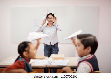 Stressed Female Teacher Crying In Noisy Classroom