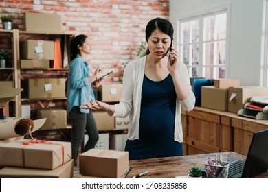 Stressed Freelance Pregnant Woman Seller Check Product Order For Delivery To Customer Talking On Smart Phone Argue Angry With Producer.