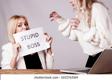 Stressed And Frightened Worker Holding Sign Stupid Boss. Conflict Concept.