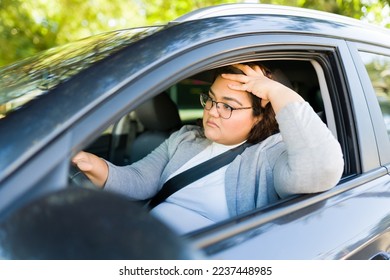 Stressed frustrated fat woman looking tired driving late to work in her car while stuck in traffic - Shutterstock ID 2237448985