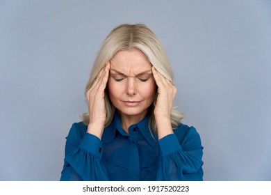 Stressed frustrated middle aged lady suffering from headache massaging temples, close up view. Tired sick mature old woman feeling unwell, touching head. Migraine pain, fatigue, stress concept
