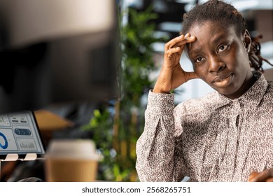 Stressed general manager working under pressure on crucial organizational tasks, dealing with burnout and mental exhaustion. African american woman getting overwhelmed by project deadlines.