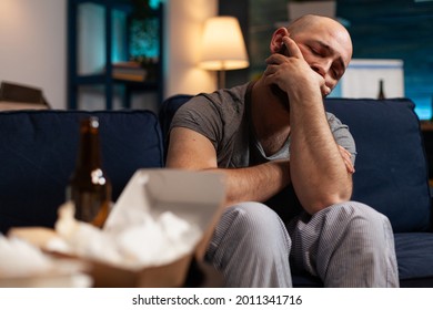 Stressed Injured Traumatised, Frustrated Man Looking In Distance, Sitting Alone On Sofa Feeling Emotionally Unstable, Mental Desperate, Vulnerable Suffering From Anxiety, Chronic Disease