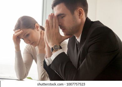 Stressed Male And Female Business Persons Sitting At Desk, Hard Thinking About Problem. Businessman And Businesswoman Shocked, Bad News, Company Bankruptcy, Mistake In Work, Big Reduction In Office