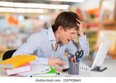 Stressed Male University Or College Student With Poor Mental Health Studying With Laptop In Room