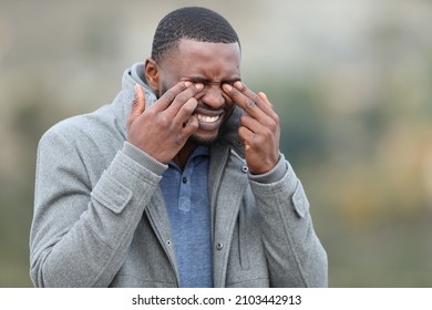 Stressed Man With Black Skin Scratching His Eyes In Winter