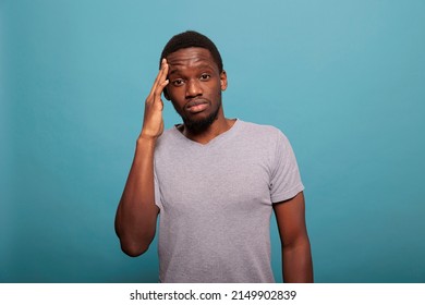 Stressed Man Dealing With Headache And Rubbing Temples To Stop Pain, Feeling Unhappy And Worried About Health Care Problems. Frustrated Person With Migraine Feeling Tension And Suffering.