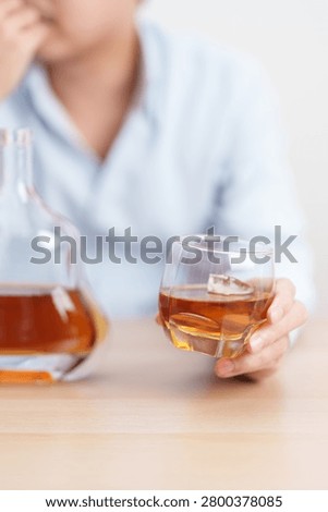 Stressed man drinking cognac alone with problem. Exhausted drunk man looking stressed and sleepy. Alcohol addiction, Alcoholism, emotional distress and mental health concept 
