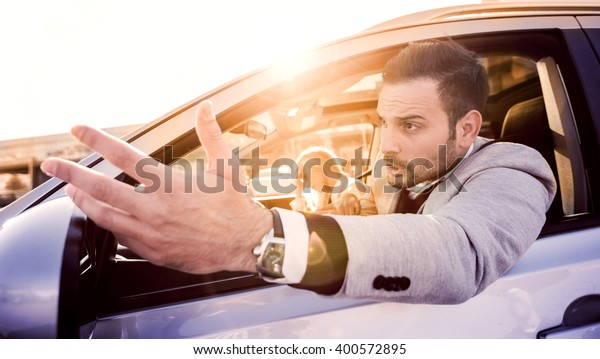 Stressed man driver - transportation\
concept.He is late for work because of traffic\
jams.