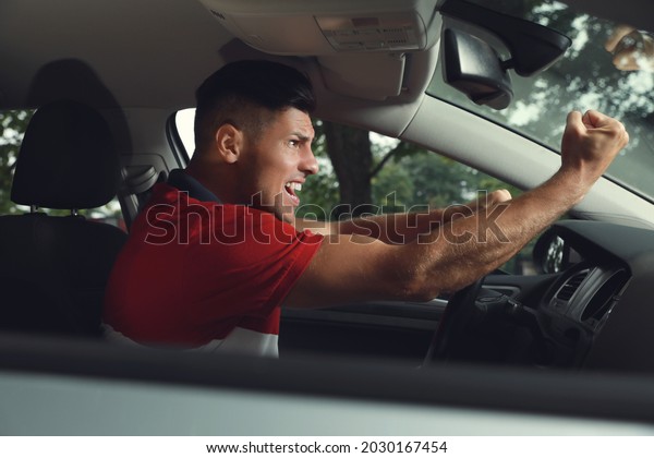 Stressed man in\
driver\'s seat of modern\
car