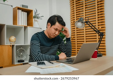 stressed man headache while working with a laptop computer at home office