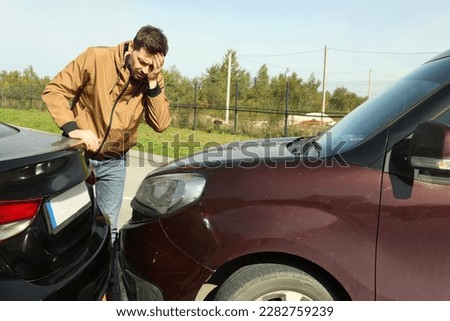 Stressed man near car with scratch outdoors. Auto accident