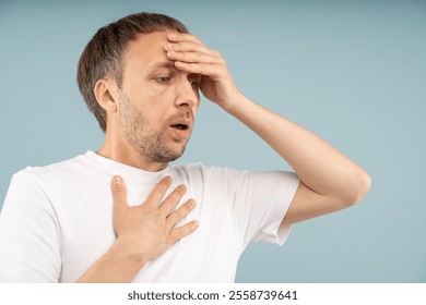 Stressed man with panic attack holding head, chest in distress tries to regain control. Anxious male with difficult breathing, rapid heartbeat feels emotional distress, chronic fear, phobias, burnout.