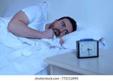 Stressed Man Trying To Sleep In His Bed At Night