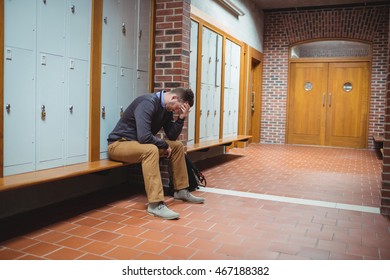 Stressed mature student sitting in locker room at college - Powered by Shutterstock