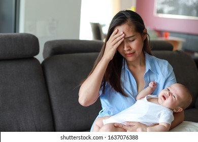 Stressed mother  depression with her crying newborn baby in her arms. Young asian mom stressful or sick concept.