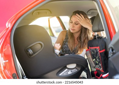 Stressed Mother With Her Baby In The Back Of The Family Car