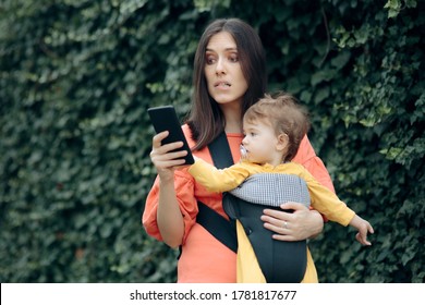 Stressed Mother Holding Smartphone Walking Baby. Busy Mom Trying To Multitask While Carrying For Her Little One
