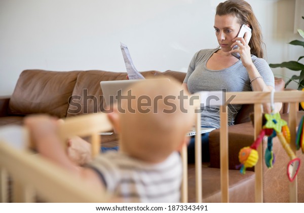 Stressed Mother On the Phone With the Laptop\
Looking At Household\
Bills
