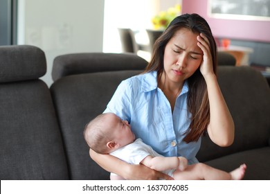 Stressed Mother Suffering Postnatal Depression With Her Crying Newborn Baby In Her Arms. Young Asian Mom Stressful Or Sick Concept.