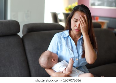 Stressed Mother Suffering Postnatal Depression With Her Crying Newborn Baby In Her Arms. Young Asian Mom Stressful Or Sick Concept.