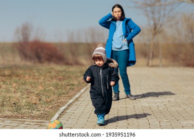 Stressed Mother Supervising Child Playing Outdoors. Overprotective Mom Watching Over Child Playing Outdoors
