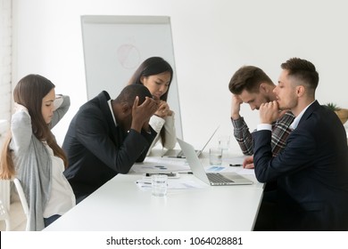 Stressed multiracial team thinking of problem solution at emergency office meeting, sad diverse business people group shocked by bad news, upset colleagues in panic after company bankruptcy concept - Powered by Shutterstock