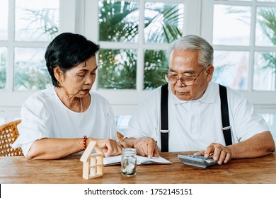 Stressed Old Asian Senior Couple Worried About Unpaid Bank Bills. Serious Elderly Family Using Calculator To Count For Loan Payment And Having Money Problem