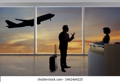 Stressed out businessman passenger arguing with a flight attendant or receptionist at an airport check in counter.  He is angry because of a delayed or cancelled flight.  