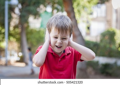 Stressed Out Little 5-year Old Caucasian Little Boy Outside Closing His Ears And Screaming Of Pain, Trauma, Traumatic Experience And Loud Noise Stock Image. Autism, Autistic Child, Asperger Syndrome