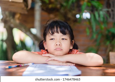 Stressed Out And Tired Asian Kids Girl Stay At Home And Learn From Home.Lazy Kid Girl Want To Go Back To School.No Online Learning.Poor Girl Do Not Have Laptop For Online Learning At Home.Education.